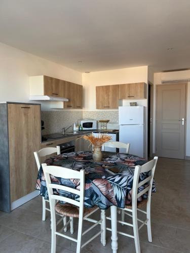 a kitchen with a table and chairs in a kitchen at Mini Villa vue mer in Sari Solenzara