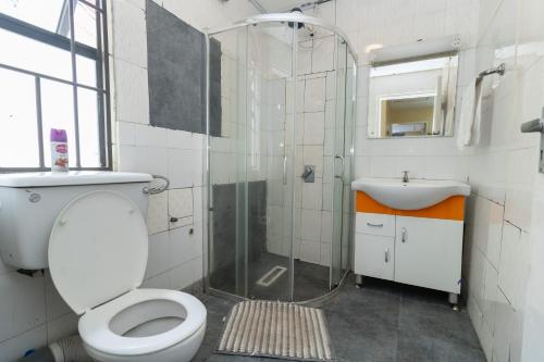 Un baño con ducha, inodoro y lavabo. en Rosa Luxury Villa near Jomo Kenyatta International Airport-JKIA, en Nairobi