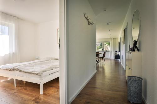 een slaapkamer met een bed en een hal met een tafel bij Ferienwohnung Hohenstein in Murrhardt