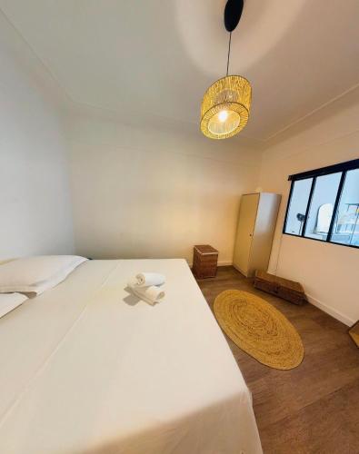 une chambre avec un grand lit blanc et une fenêtre dans l'établissement Le poulpe du port, à Marseille