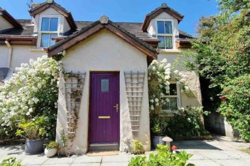 una casa con una puerta morada en Orchard Cottage, en Dingle