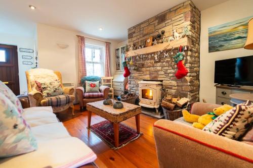 a living room with a fireplace and a stone wall at Orchard Cottage in Dingle