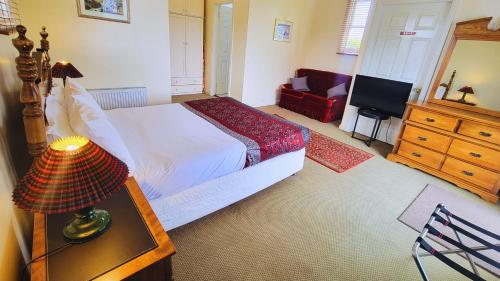 a bedroom with a bed and a dresser and a television at Leura House in Leura