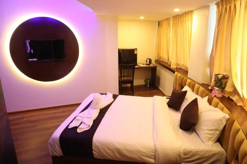 a bedroom with a bed with a tv on the wall at Hotel Air Stay Inn - Andheri East in Mumbai