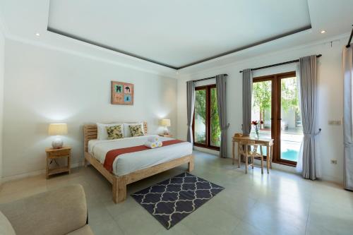 a bedroom with a bed and a large window at Deby Villa Seminyak in Seminyak