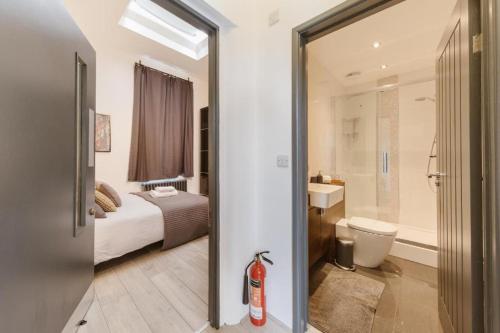 a bedroom with a bed and a bathroom with a toilet at Grand Prix House in London