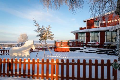 a house with a fence in the snow at Tällbergsgårdens Hotell in Tällberg