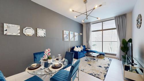 a living room with a table and blue chairs at Primestay - Prime Views 1BR - Meydan in Dubai