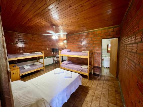 a room with three bunk beds in a brick wall at Casona Rural Km 1469 in Puerto Rico