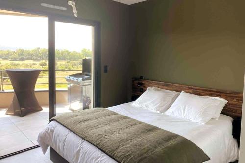 une chambre avec un lit et une grande fenêtre dans l'établissement Appartement au cœur de Porto Vecchio, wi-fi, à Porto-Vecchio