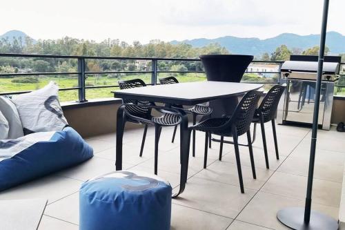- un balcon avec une table, des chaises et un grill dans l'établissement Appartement au cœur de Porto Vecchio, wi-fi, à Porto-Vecchio