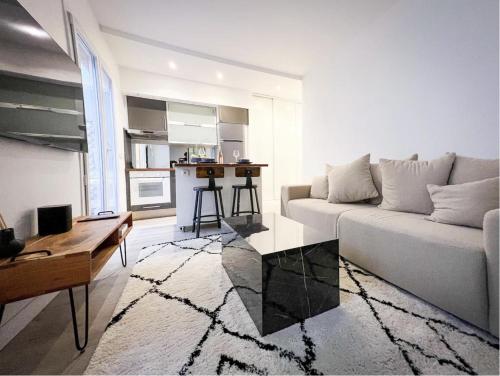 un salon avec un canapé blanc et une table dans l'établissement Suite luxueuse avec jardin privatif et jacuzzi, à Paris