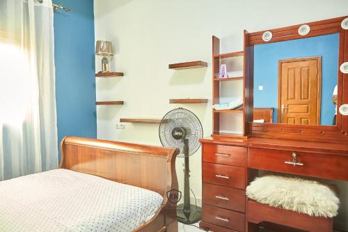 um quarto com uma cómoda e um espelho em Résidence EKA Tonfack em Iaundé