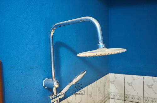 um chuveiro com uma faca fixada a uma parede azul em Résidence EKA Tonfack em Iaundé