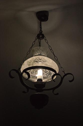 a chandelier hanging from a ceiling with a light at Archontariki Guesthouse in Poligiros