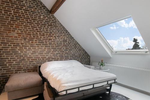 a bedroom with a bed and a brick wall at Pastoria Residence in Maastricht