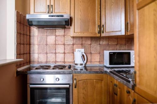 uma cozinha com um fogão e um micro-ondas em Amoret Apartments em Dubrovnik