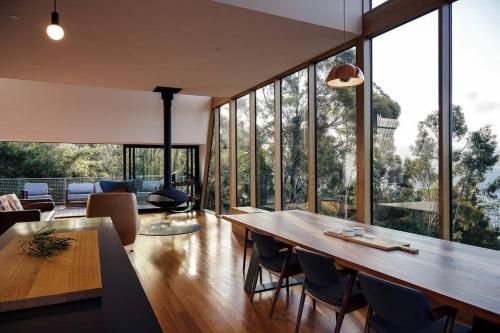 a living room with a large wooden table and chairs at Apollo Bay House in Woodbridge