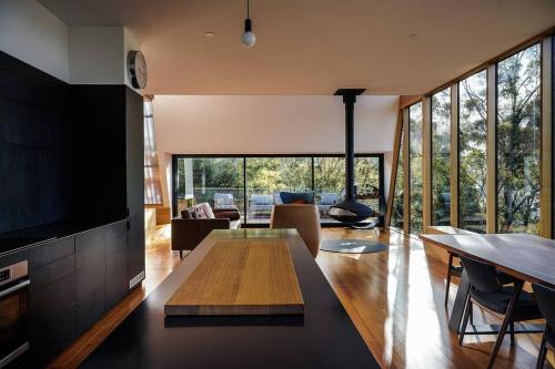 a living room with a table and a large window at Apollo Bay House in Woodbridge
