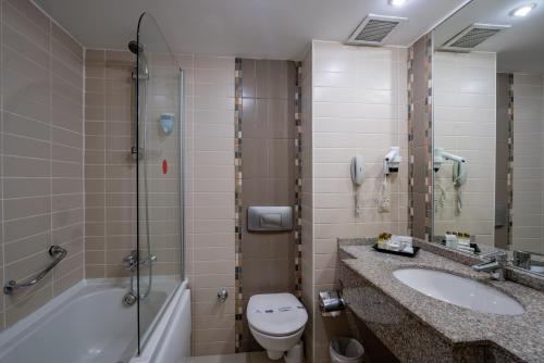 y baño con aseo, lavabo y ducha. en Palmeras Beach Hotel Ultra All Inclusive en Konaklı