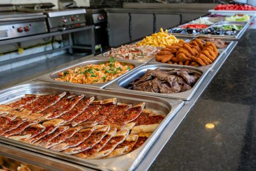 ein Buffet mit vielen verschiedenen Speisen in der Unterkunft Palmeras Beach Hotel Ultra All Inclusive in Konaklı