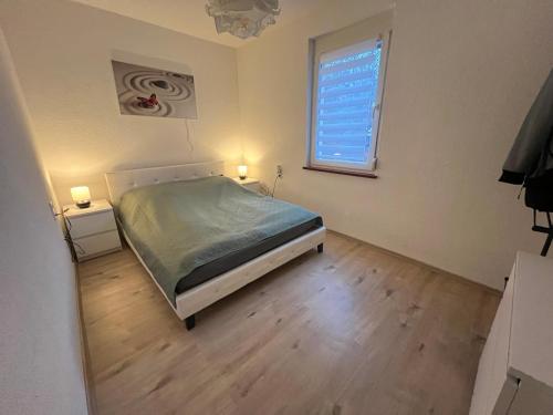 Schlafzimmer mit einem Bett und einem Fenster in der Unterkunft Gemütliche 2 Z. Wohnung mit Charme in Trossingen