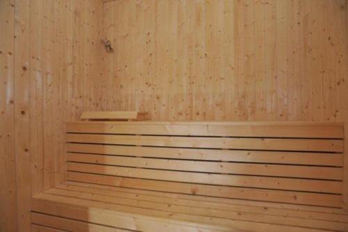 a sauna with a wooden wall and a wooden bench at Ustedalen Hotel Geilo in Geilo