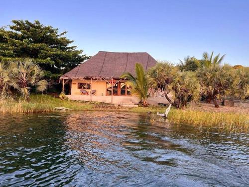 una casa en la orilla de un cuerpo de agua en Lakeside Paradise Inhambane en Ligogo