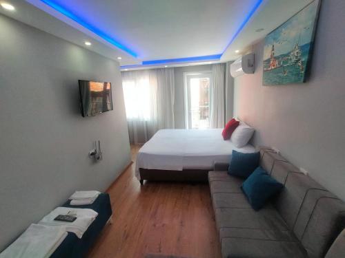 een slaapkamer met een bed en een bank in een kamer bij BlueRoyal Grand Bazaar in Istanbul