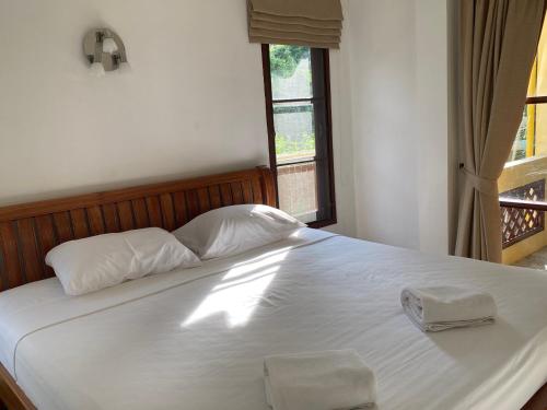 a bed with two white pillows and a window at Samui Green Life in Bophut 