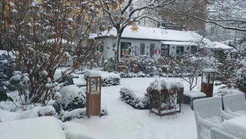 a garden covered in snow in front of a house at Gastehaus HH- Winterhude in Hamburg