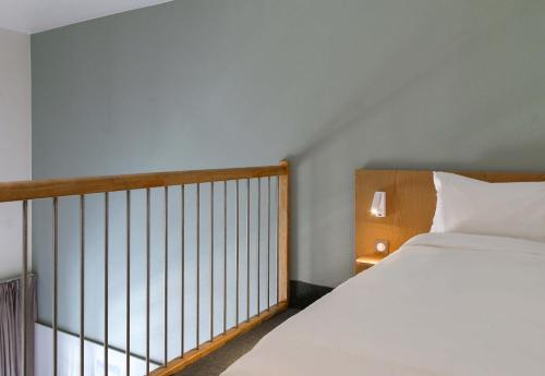 a bedroom with a white bed and a balcony at B&B HOTEL Marseille Euromed in Marseille