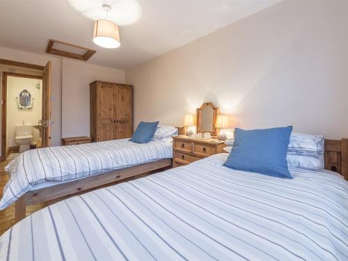 a bedroom with two beds with blue pillows at 2 bed property in Mundesley Norfolk KT044 in Mundesley