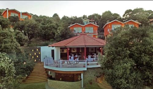 ein Haus mit Leuten, die auf einer Veranda sitzen in der Unterkunft Essence of Nature, Ranikhet in Rānīkhet