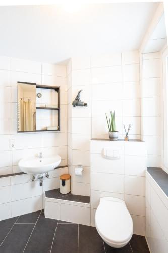 a white bathroom with a sink and a toilet at -Super zentrales Zimmer- direkt an der Lutter! in Bielefeld