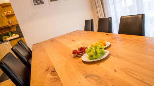 a table with two plates of fruit on it at Haus Alpenglück in Saas-Fee