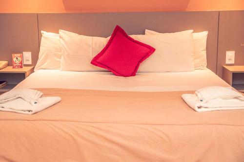 a large white bed with two towels on it at STALO HOTEL in Piumhi