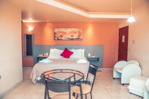 1 dormitorio con 1 cama con mesa y sillas en STALO HOTEL, en Piauí
