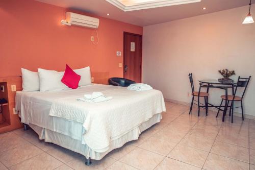 a bedroom with a large bed and a table at STALO HOTEL in Piumhi