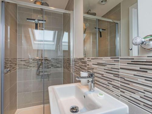 a bathroom with a sink and a shower and a mirror at 2 Bed in Westward Ho 73566 in Westward Ho