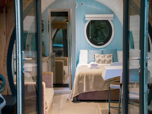 Schlafzimmer mit einem Bett und einem runden Fenster in der Unterkunft 1 Bed in New Quay 77496 in Lampeter
