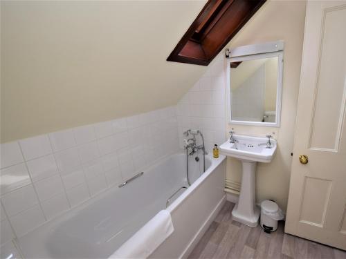 a white bathroom with a sink and a bath tub at 2 Bed in Kinlocheil CA138 in Fassfern
