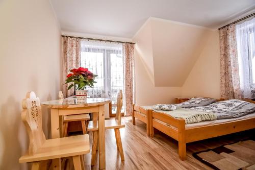 a bedroom with a bed and a table and a desk at Apartamenty u Gabi in Poronin