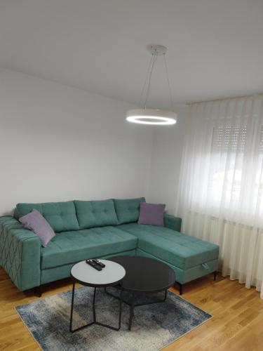 a living room with a green couch and a table at STUDIO 15 in Vranješ