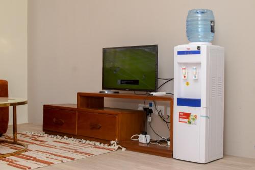Cette chambre dispose d'un refroidisseur d'eau et d'une télévision. dans l'établissement Three Cozy Bedrooms at Palm Ridge, à Vipingo