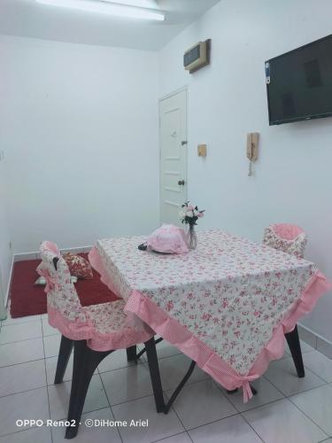 mesa con mantel rosa y 2 sillas en Dihome Ariel, en Donggongon