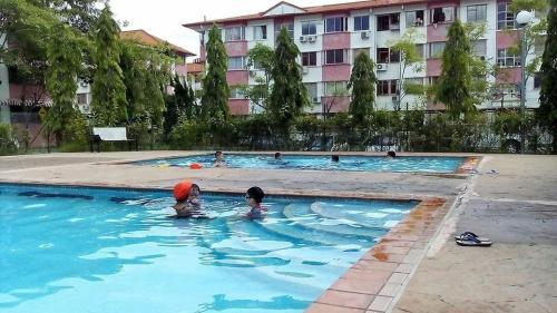 dos niños nadando en una piscina en un edificio en Dihome Ariel, en Donggongon