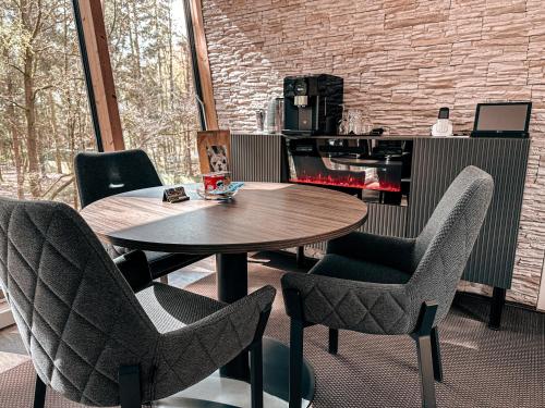 a table and chairs in a room with a fireplace at Tree Inn - Das Baumhaushotel in Dörverden