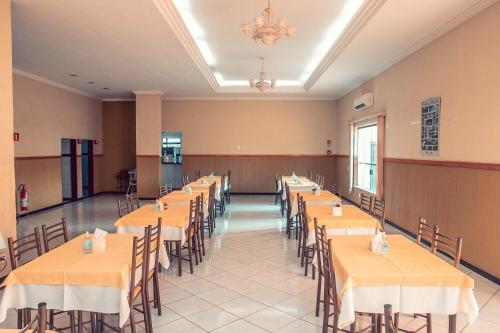um grande salão de banquetes com mesas e cadeiras em STALO HOTEL em Piuí