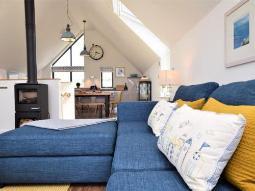 ein Wohnzimmer mit einem blauen Sofa und einer Küche in der Unterkunft 4 Bed in Westward Ho 75358 in Northam